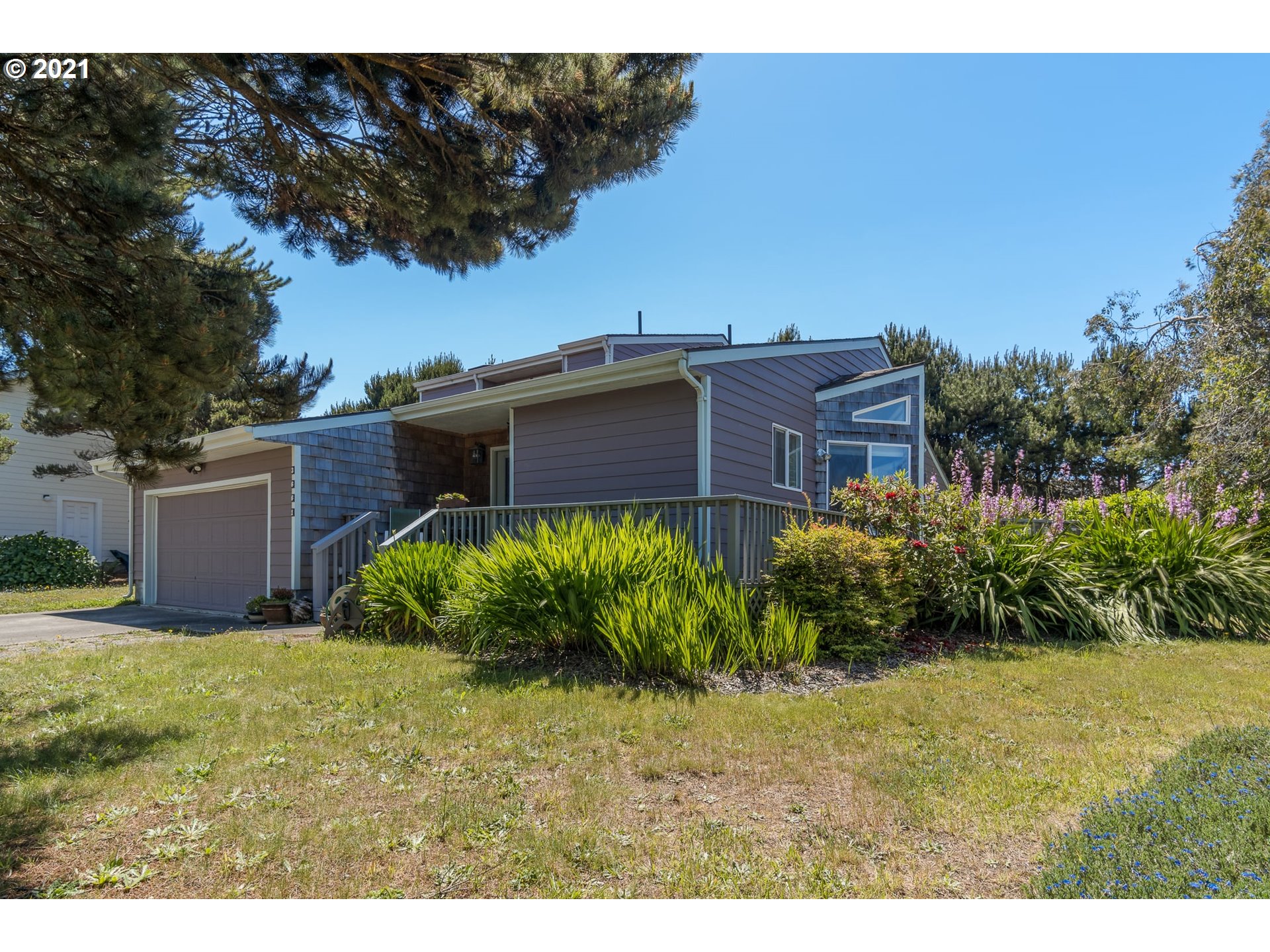 3661 Natalie Way Bandon, OR 97411 - Photo 2 of 32 a view of a large garden with plants and large trees