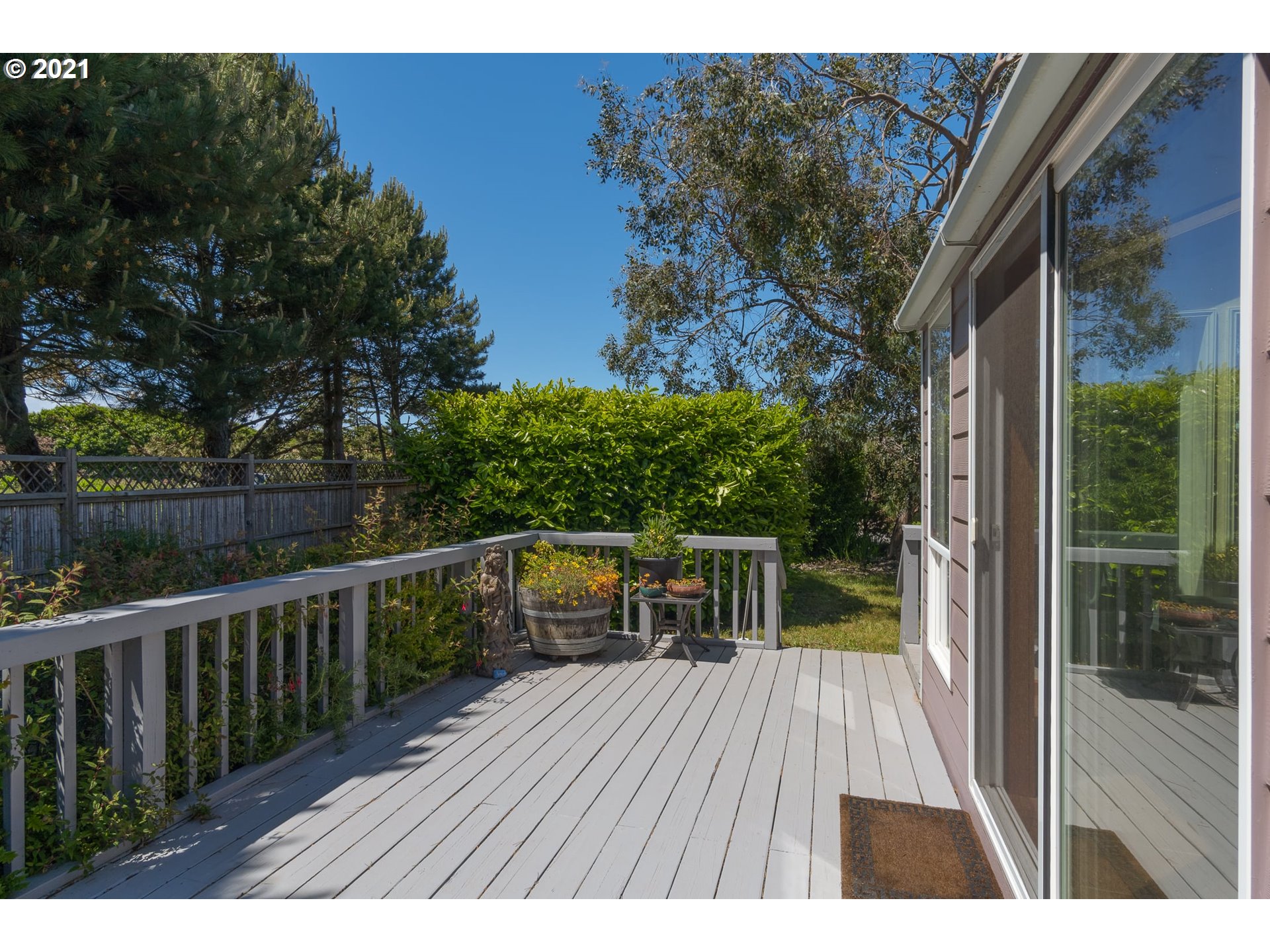 3661 Natalie Way Bandon, OR 97411 - Photo 6 of 32 a balcony with wooden floor and yard in the back