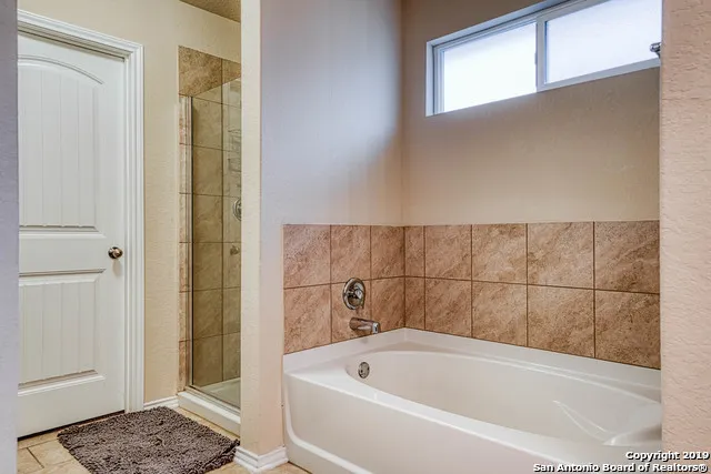 a bathroom with a tub and shower