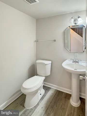 a bathroom with a toilet a sink and mirror