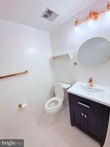 a bathroom with a toilet a sink and mirror