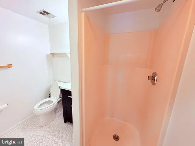 a white toilet sitting next to a shower