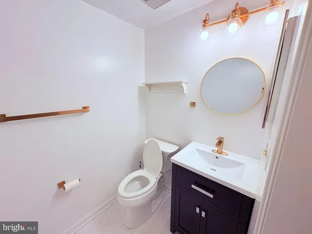 a bathroom with a sink vanity granite and toilet