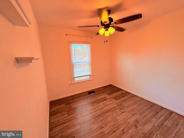 a view of a room with a window and a ceiling fan