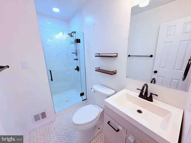 a bathroom with a sink toilet a mirror and shower