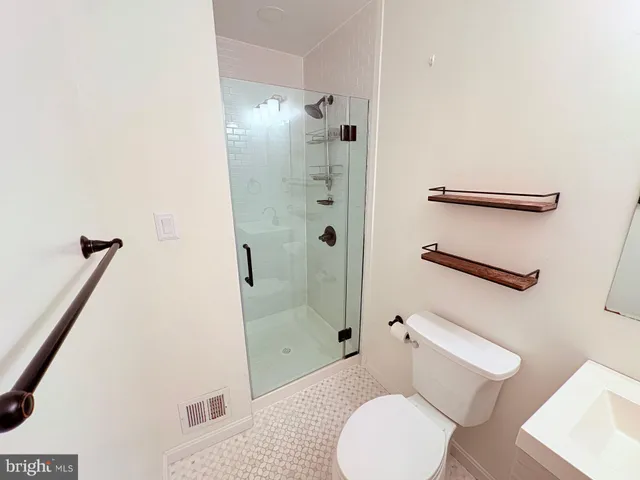 a white toilet sitting next to a bath tub