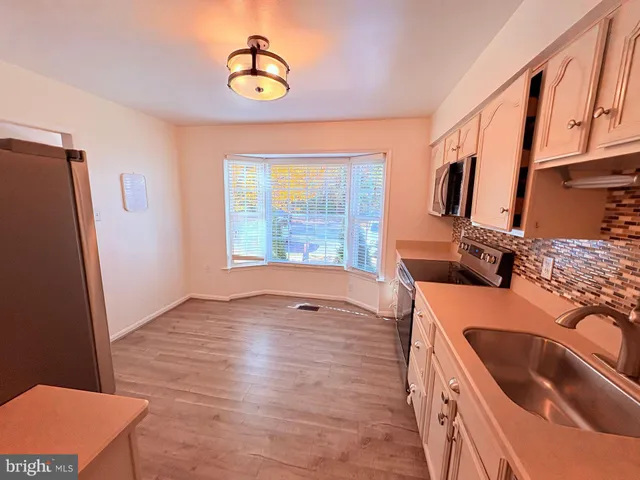 a kitchen with granite countertop a sink and a refrigerator