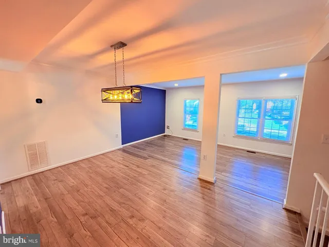 a view of a kitchen with wooden floor a ceiling fan and a window
