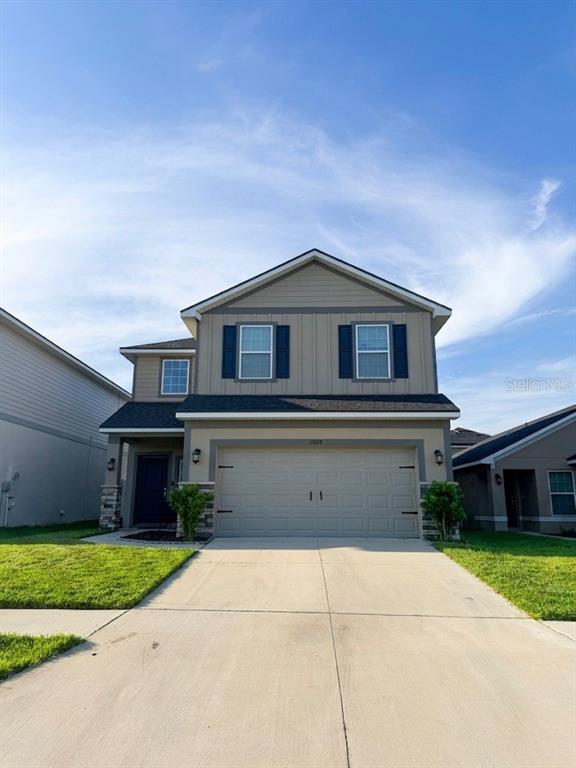 13058 Ogden Glade Road Dade City, FL 33525 - Photo 1 of 14 a front view of a house with a yard and garage