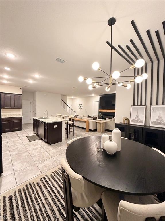 13058 Ogden Glade Road Dade City, FL 33525 - Photo 3 of 14 a kitchen with a table chairs and flat screen tv