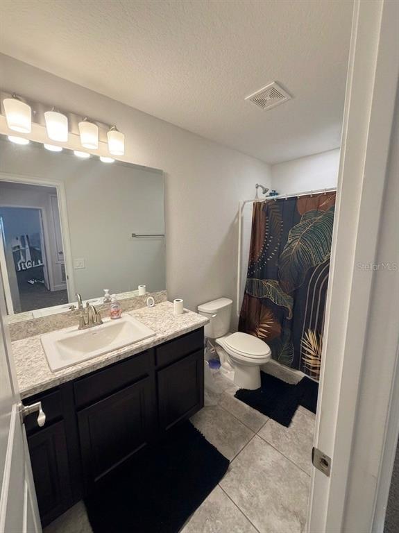 13058 Ogden Glade Road Dade City, FL 33525 - Photo 8 of 14 a bathroom with a granite countertop toilet sink and mirror