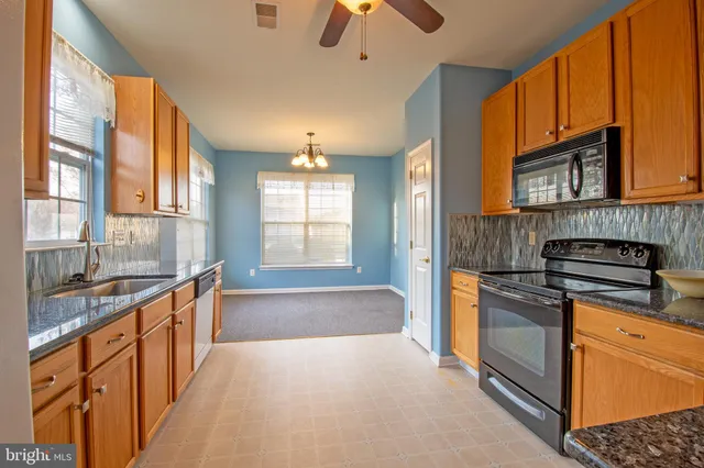 a kitchen with stainless steel appliances granite countertop a stove and a sink