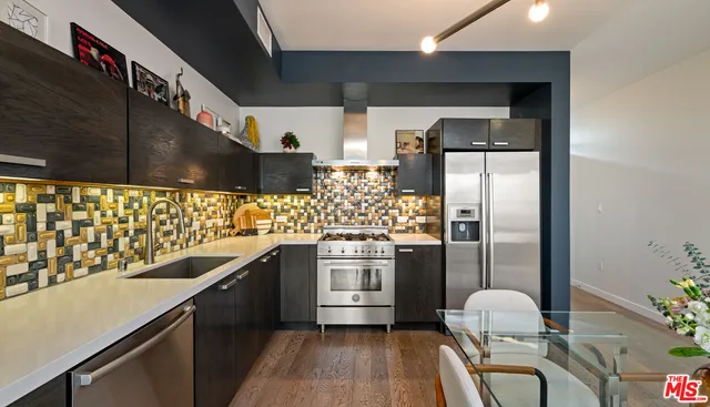 a kitchen with stainless steel appliances a sink stove and refrigerator