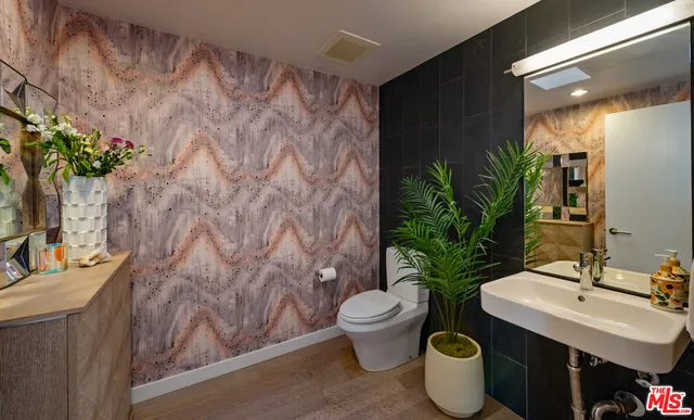 a bathroom with a toilet sink and mirror
