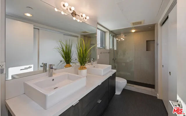 a bathroom with a sink a large mirror and a shower