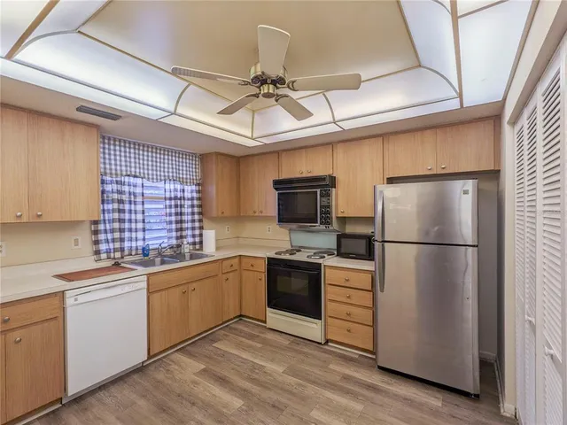 a kitchen with a sink stainless steel appliances and white cabinets