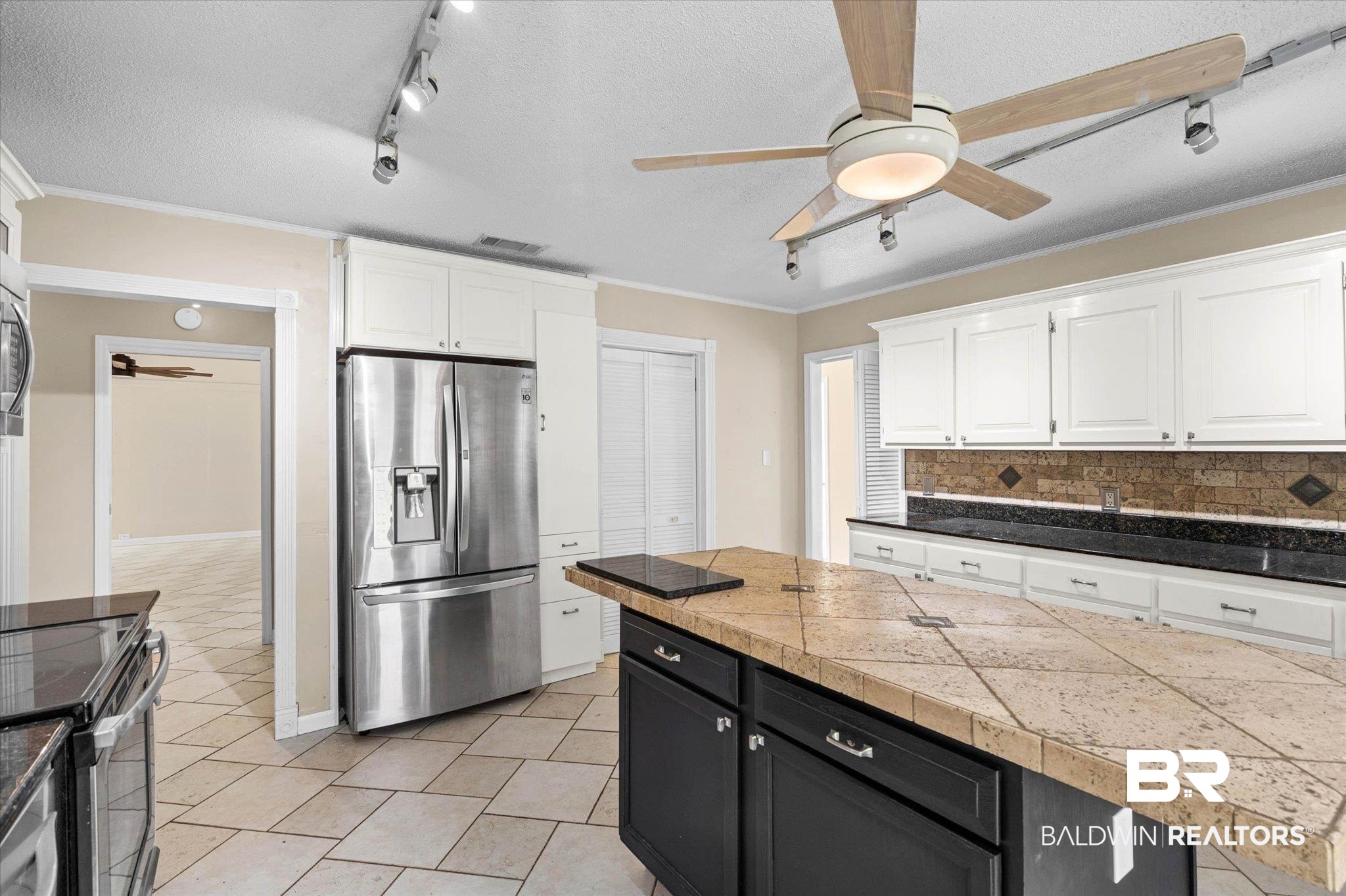 3724 Claridge Road South Mobile, AL 36608 - Photo 10 of 42 Two tone kitchen with a ceiling fan, dual tone cabinets, stainless steel appliances, ornamental molding, and a textured ceiling