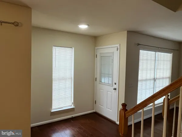 an entryway with wooden floor and windows