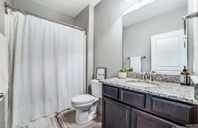 a bathroom with a granite countertop sink and a mirror
