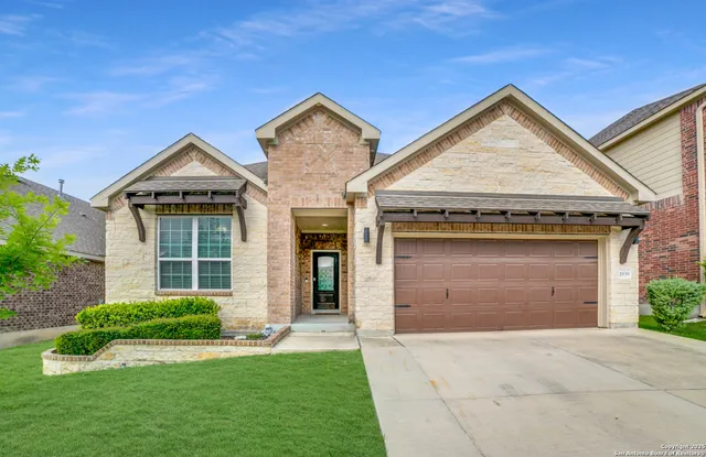 front view of a house with a yard and garage