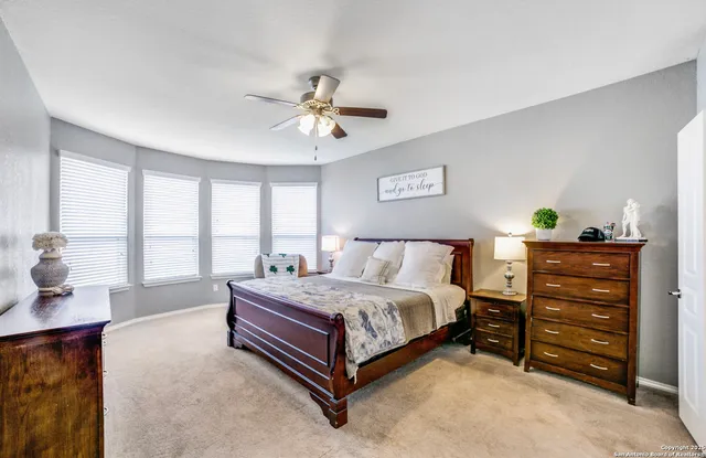 a spacious bedroom with a bed and ceiling fan