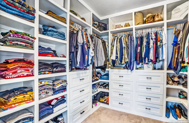 a view of walk in closet with clothes and shoes