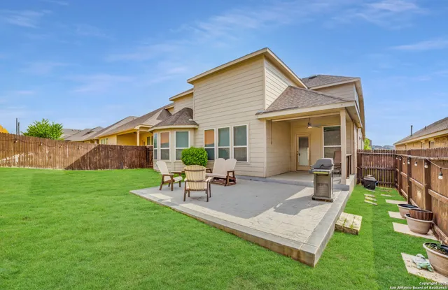 a view of a house with a yard and sitting area