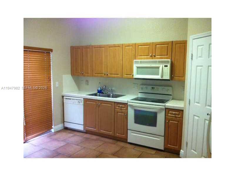 1979 Southeast 23rd Terrace, Unit 1979 Homestead, FL 33035 - Photo 2 of 4 a kitchen with a stove and a microwave