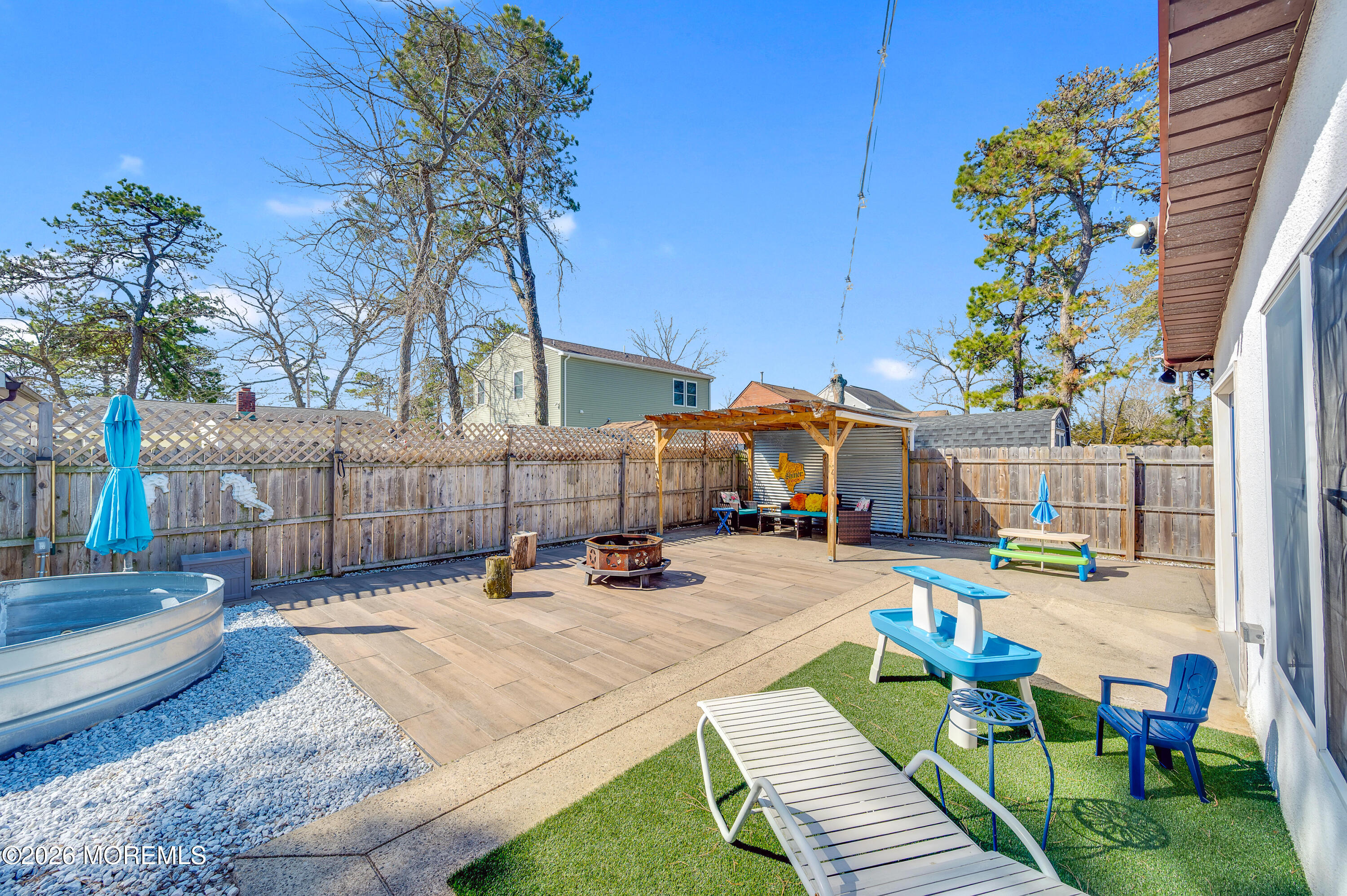 715 Tampa Road Forked River, NJ 08731 - Photo 34 of 44 a view of a patio with couches table and chairs under an umbrella with potted plants