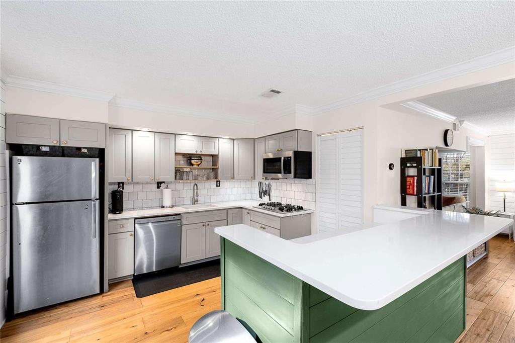 5 Spinning House Place Northwest Atlanta, GA 30318 - Photo 11 of 42 a kitchen with white cabinets and stainless steel appliances