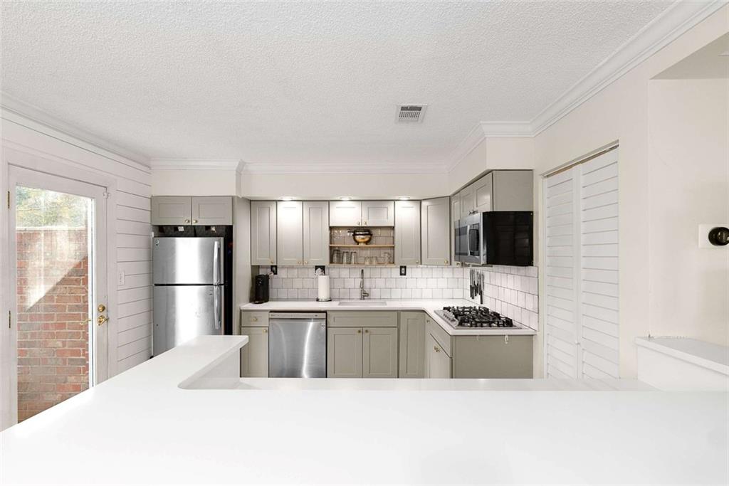 5 Spinning House Place Northwest Atlanta, GA 30318 - Photo 12 of 42 a large white kitchen with a sink a refrigerator and a stove top oven with wooden floor