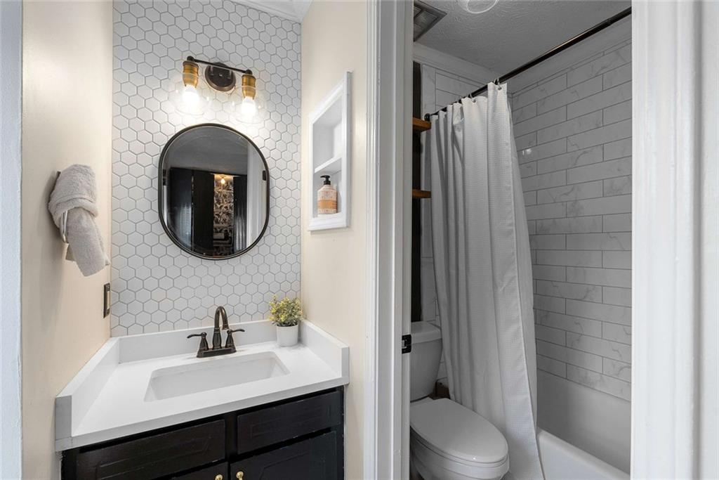 5 Spinning House Place Northwest Atlanta, GA 30318 - Photo 18 of 42 a bathroom with a toilet sink vanity tub and mirror