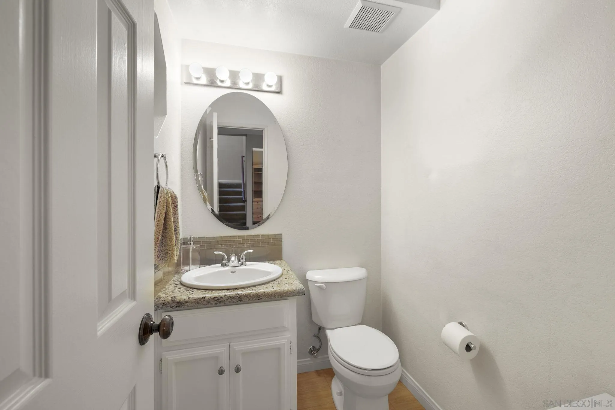 677 Summer View Circle Encinitas, CA 92024 - Photo 13 of 58 a bathroom with a granite countertop toilet a sink and mirror