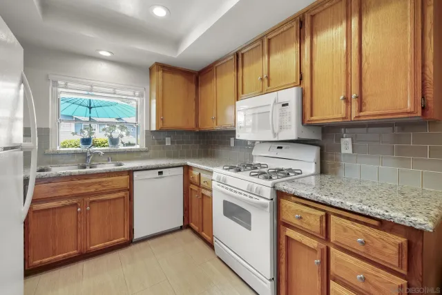 a kitchen with refrigerator a stove a sink and a window