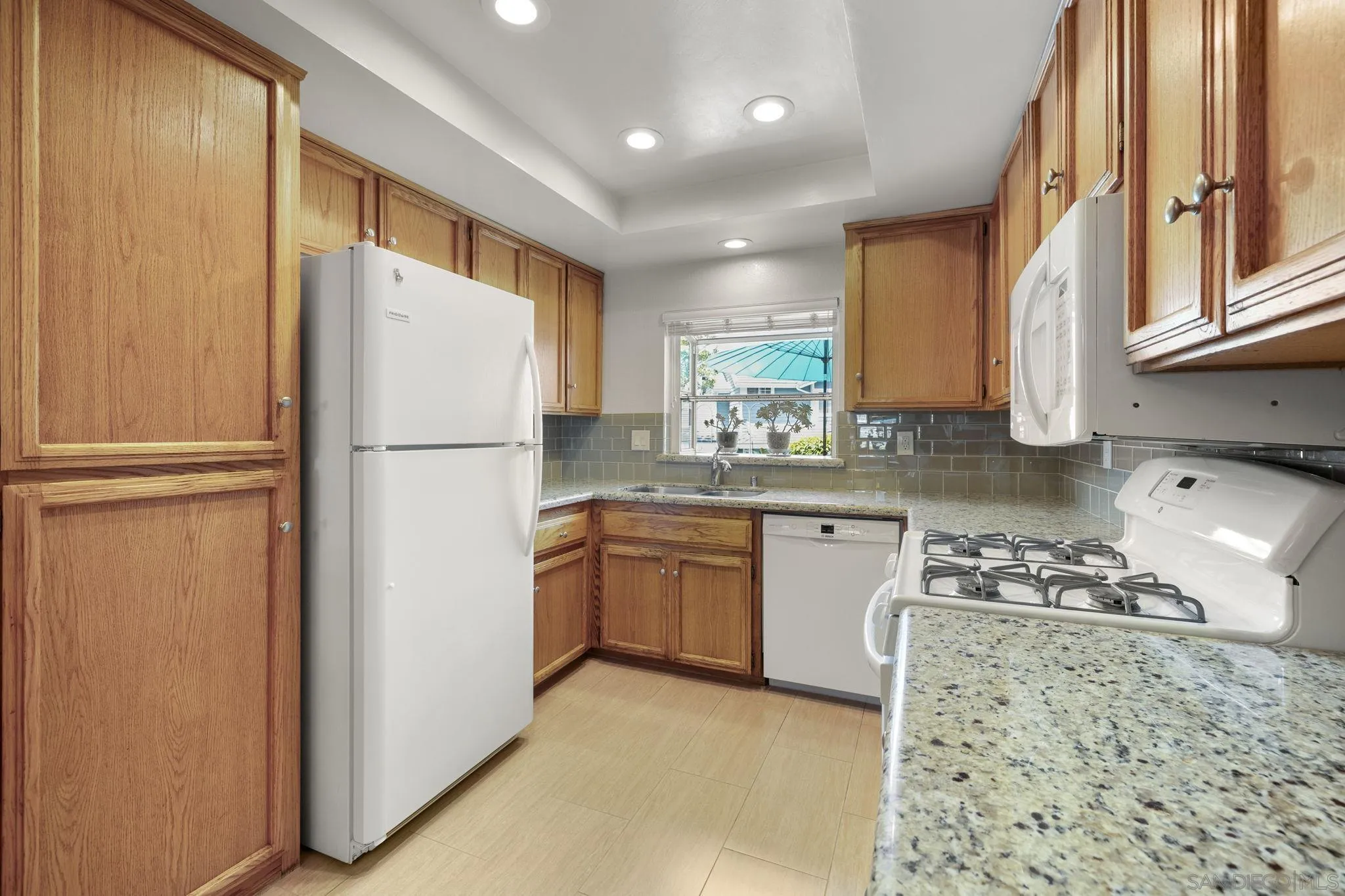 677 Summer View Circle Encinitas, CA 92024 - Photo 9 of 58 a kitchen with refrigerator a stove a sink and a window