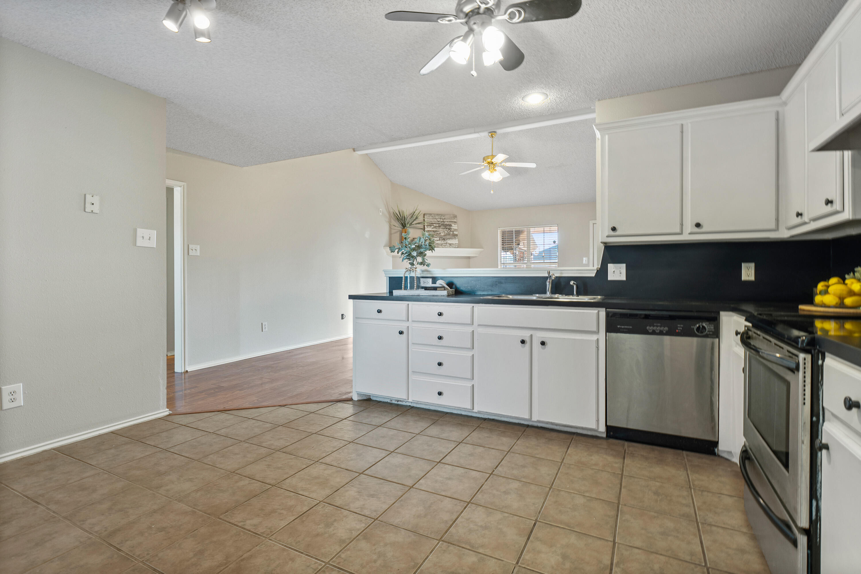 1701 79th Street Lubbock, TX 79423 - Photo 11 of 26 a kitchen with a sink window and cabinets