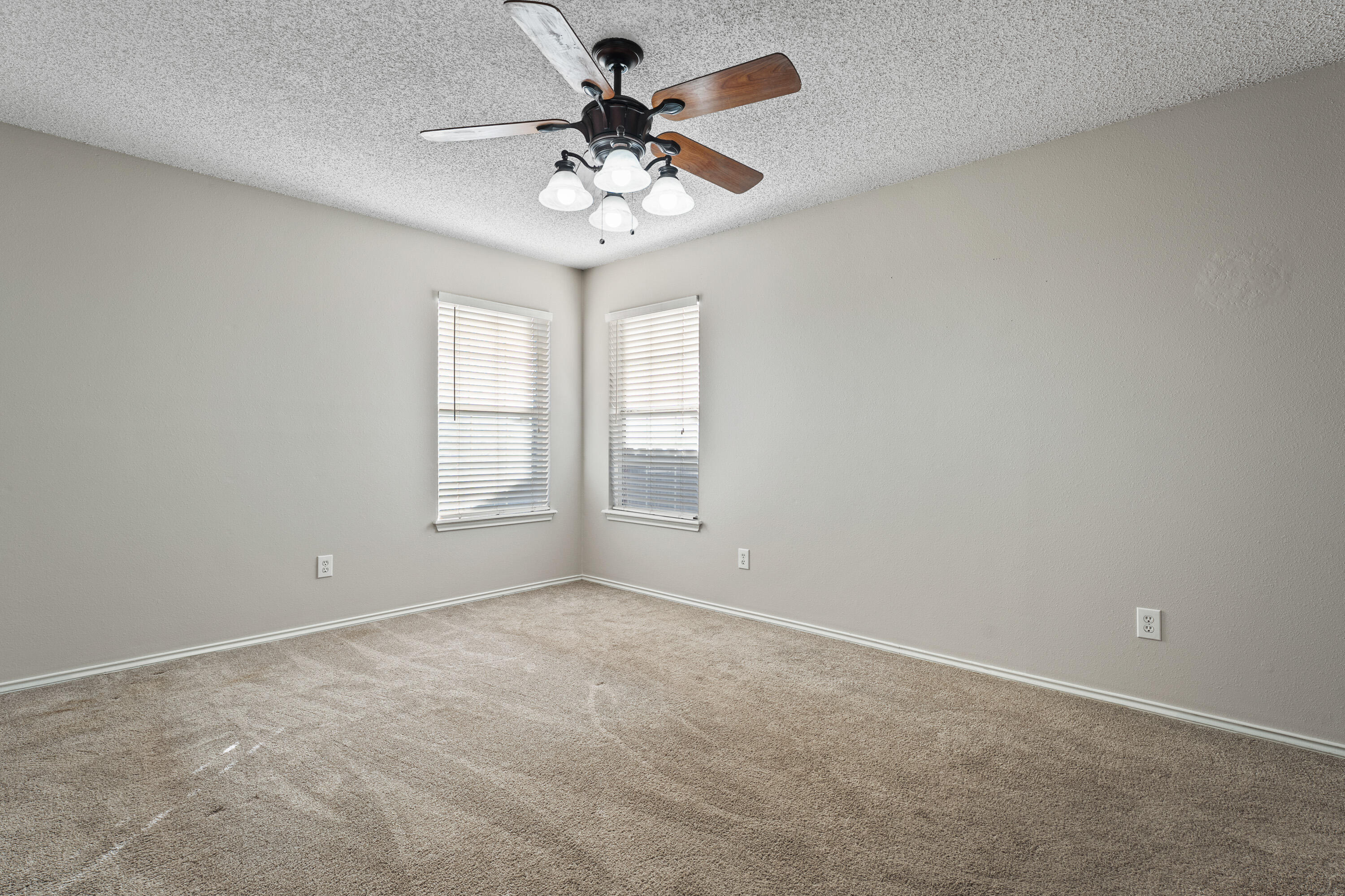1701 79th Street Lubbock, TX 79423 - Photo 14 of 26 an empty room with a chandelier fan and windows