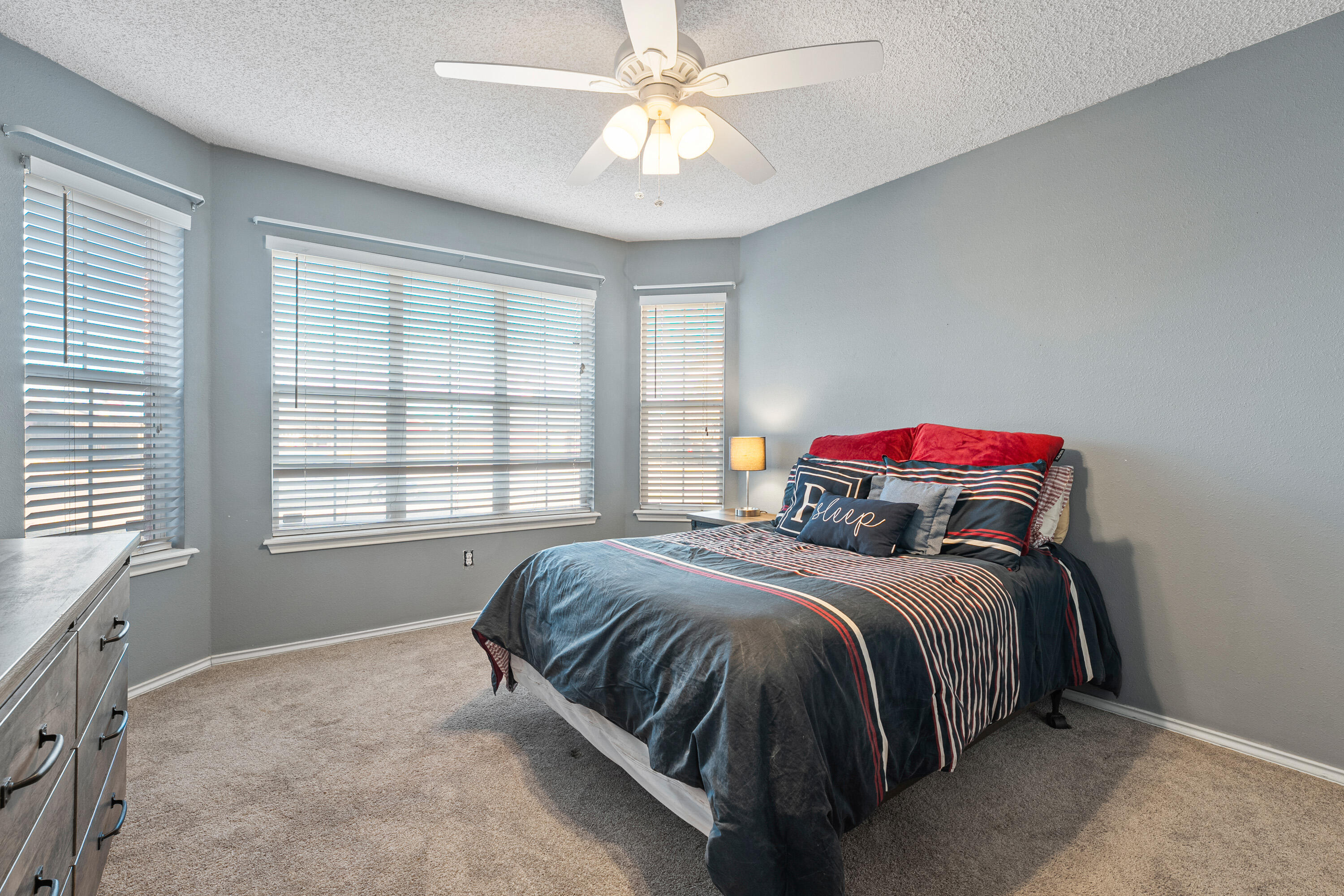 1701 79th Street Lubbock, TX 79423 - Photo 18 of 26 a bedroom with a bed and a chandelier