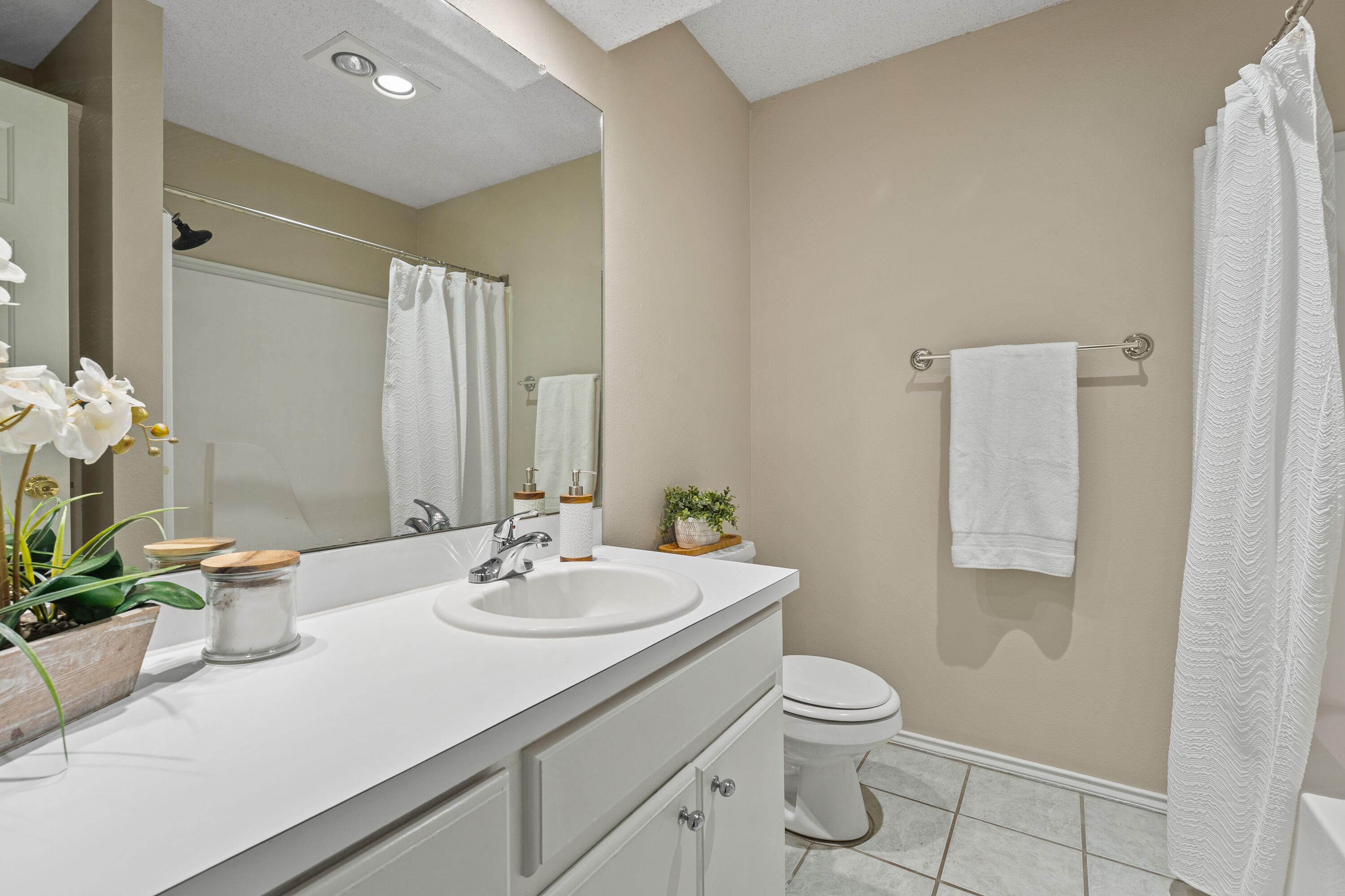 1701 79th Street Lubbock, TX 79423 - Photo 20 of 26 a bathroom with a granite countertop sink a toilet and a mirror