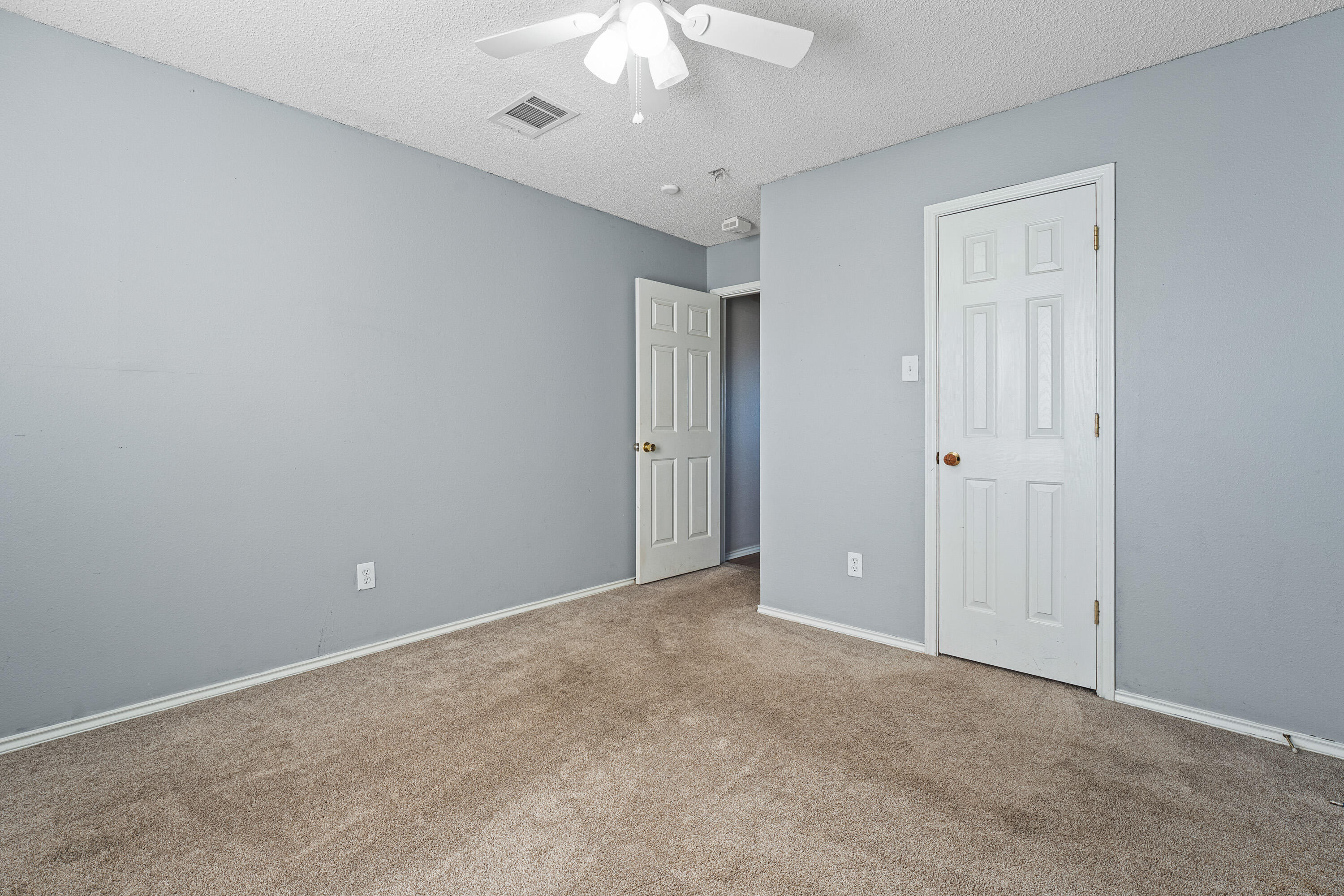 1701 79th Street Lubbock, TX 79423 - Photo 22 of 26 an empty room with a chandelier fan and closet area
