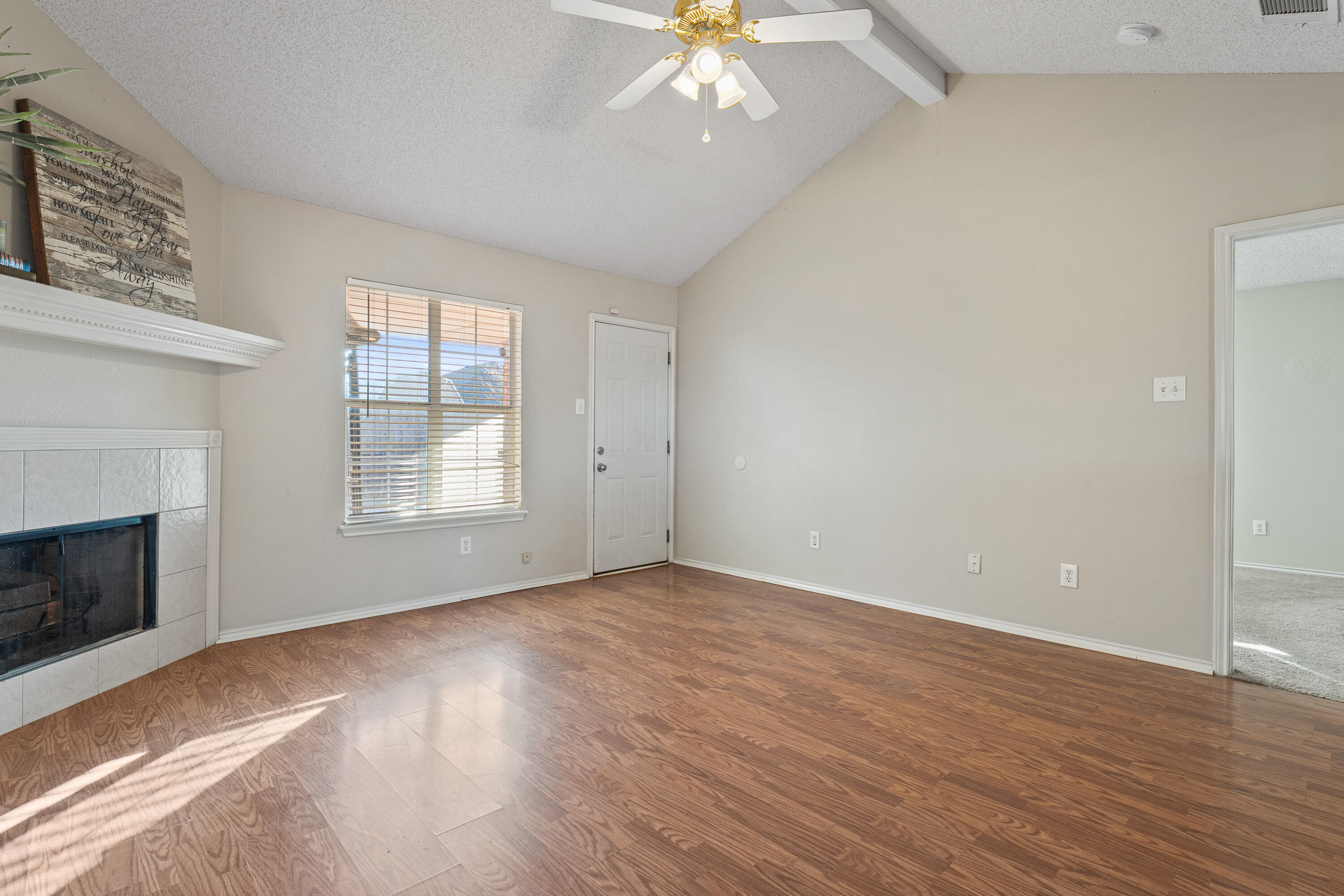 1701 79th Street Lubbock, TX 79423 - Photo 4 of 26 a view of an empty room with wooden floor fireplace and a window