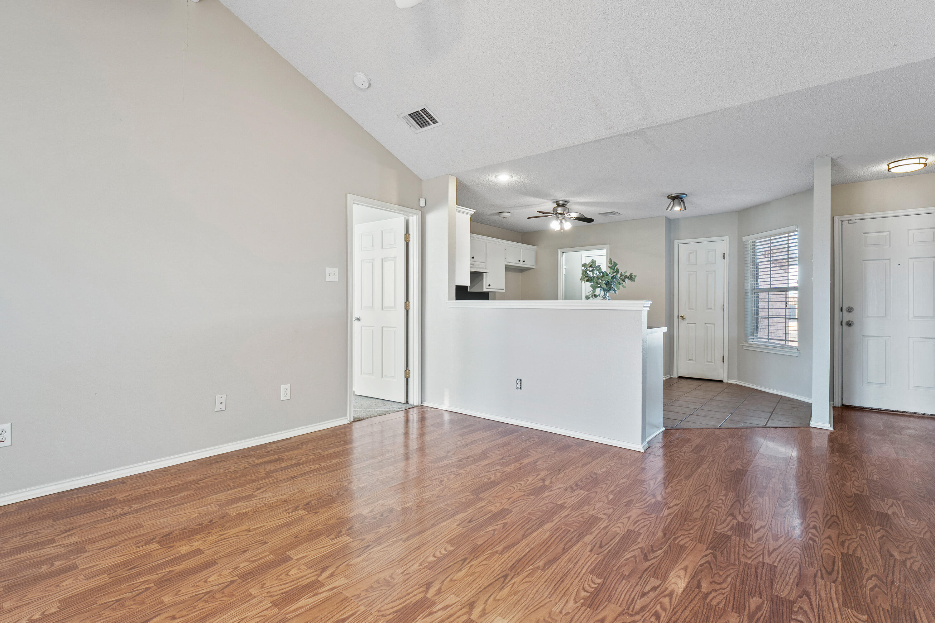 1701 79th Street Lubbock, TX 79423 - Photo 6 of 26 a view of a kitchen with wooden floor and a refrigerator