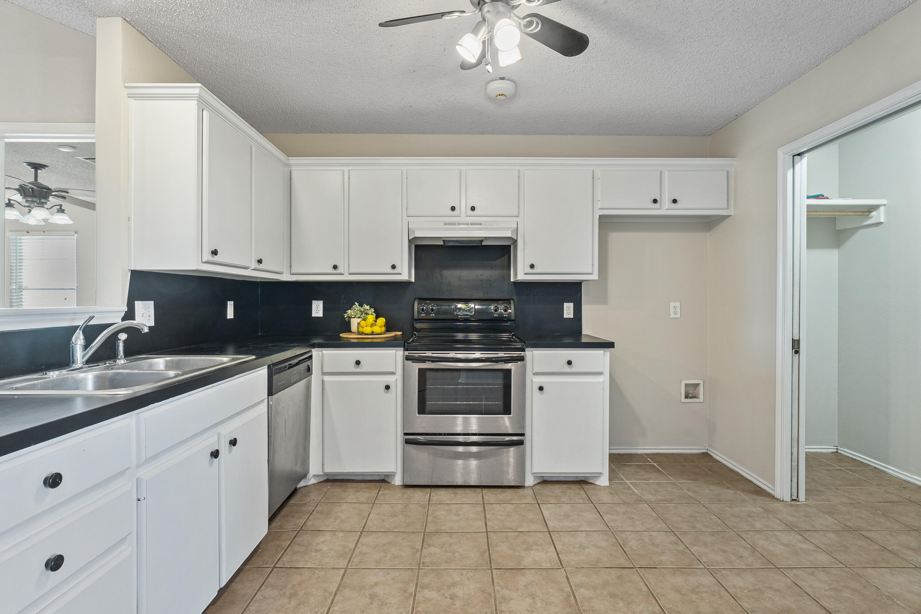 1701 79th Street Lubbock, TX 79423 - Photo 10 of 26 a kitchen with granite countertop white cabinets stainless steel appliances and a sink