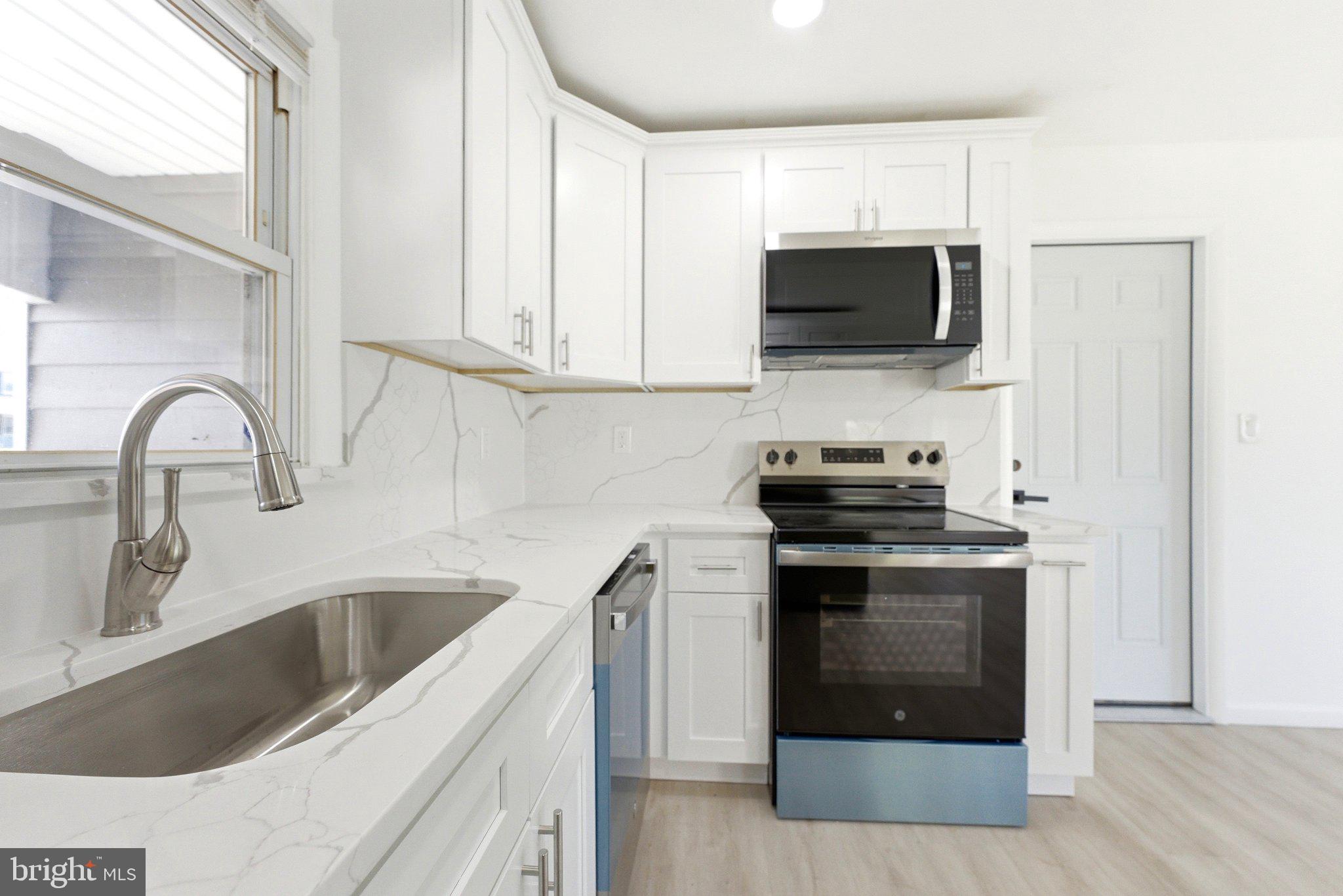 49 Middleton Lane Willingboro, NJ 08046 - Photo 6 of 23 a kitchen with stainless steel appliances granite countertop a sink stove and microwave