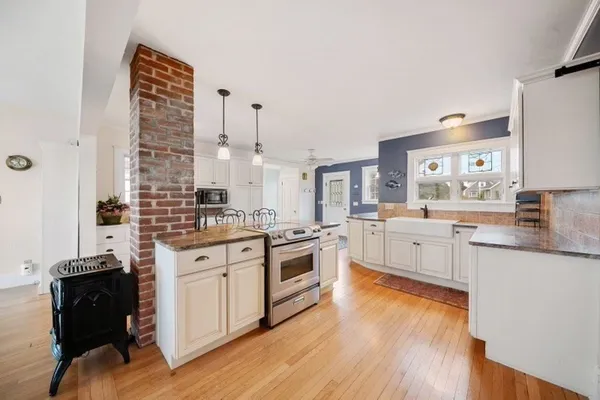 a large kitchen with kitchen island a large counter space a sink appliances and cabinets