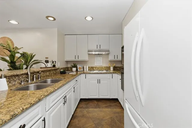 a kitchen with stainless steel appliances granite countertop a sink a stove and cabinets