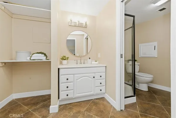 a bathroom with a granite countertop toilet a sink and a mirror