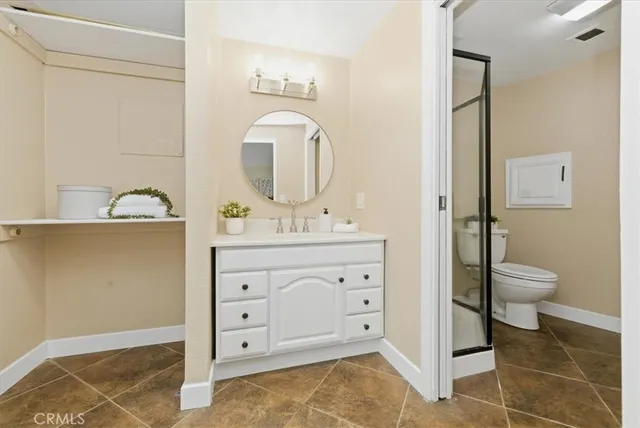 a white toilet sitting next to a bathroom sink and vanity