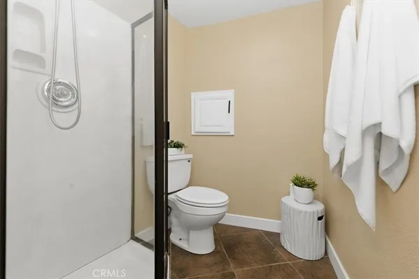 a white toilet sitting next to a bath tub
