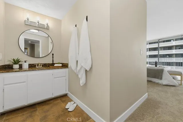a bathroom with a granite countertop toilet a sink and a mirror
